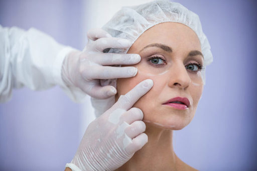 doctor-examining-female-patients-face-cosmetic-tre